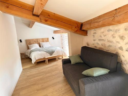 un salon avec un canapé et un lit dans l'établissement Le Petit Mas Courriol, à Courry