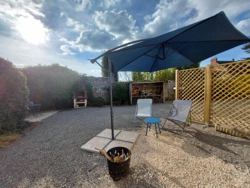 a blue umbrella and two chairs and a table at Virginie & Yann in Saint-Léger-les-Vignes