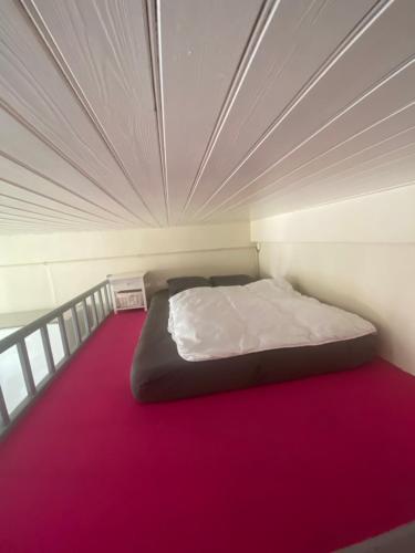 a bed in a small room with a purple floor at Studio Remblai LS in Les Sables-d'Olonne