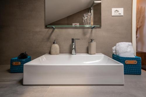 a white sink in a bathroom with a mirror at Piazza Maggiore Santa Margherita b&b in Bologna