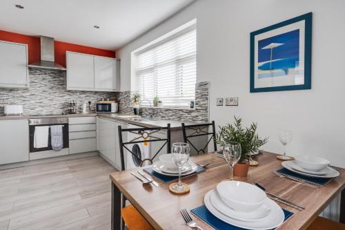 a kitchen and dining room with a wooden table with plates at Hill Lane in Central Manchester - Free Parking in Manchester