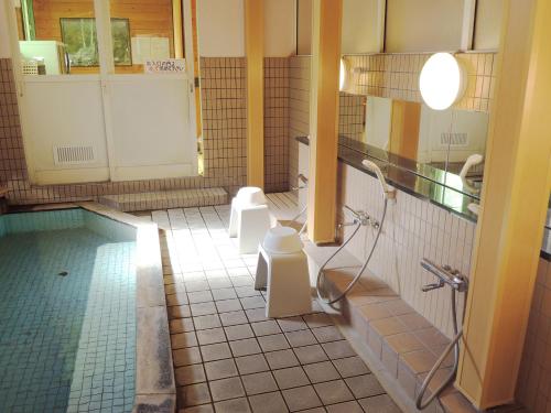 ein Badezimmer mit zwei WCs und einer Dusche darin in der Unterkunft Kokoro no sato in Kamishihoro