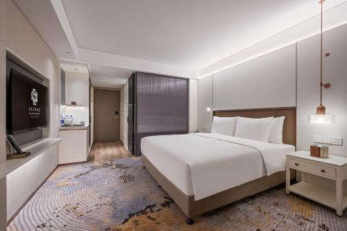 a bedroom with a large white bed and a television at Sunworld Dynasty Hotel Beijing Wangfujing in Beijing