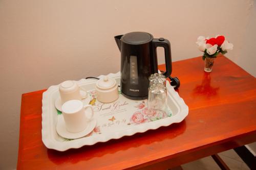 a tray with a tea kettle and cups on a table at Gangilonga Home's in Iringa