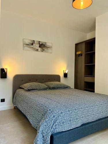 une chambre avec un lit avec une couette bleue dans l'établissement Charment 2 Pièces indépendant villa, à Mougins