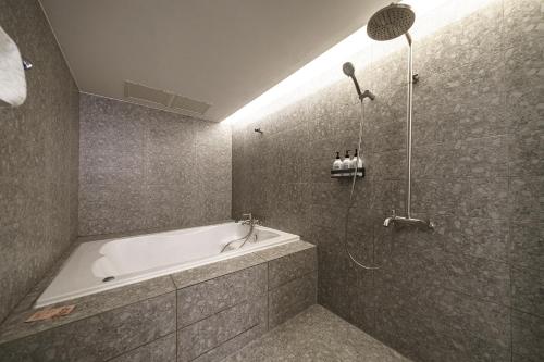 un baño con bañera y ducha en HOTEL H, en Seúl