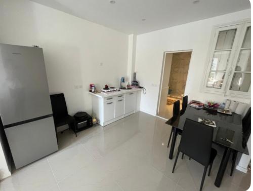a white kitchen with a table and a refrigerator at Chambre à Drancy in Drancy