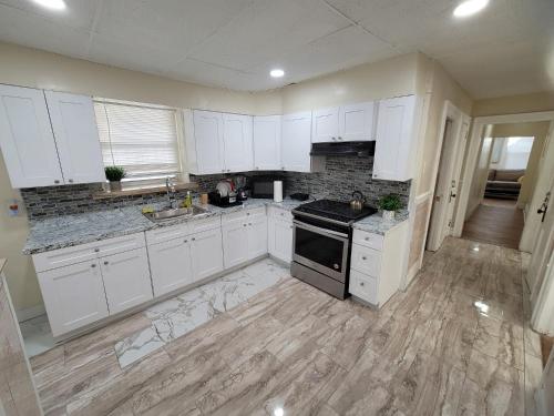 uma cozinha com armários brancos e um forno com placa de fogão em Z & Z apartment em Newark