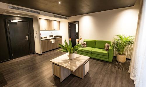 a living room with a green couch and a table at ONOMO Hotel Durban in Durban