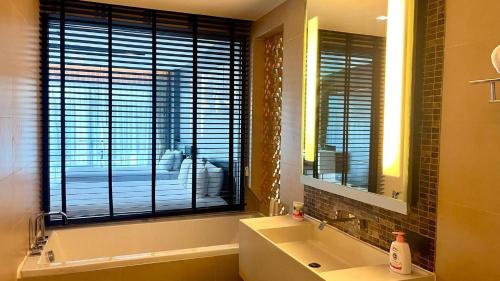 un bagno con un lavandino, uno specchio e una finestra di 4605-5-star Seaview Aparthotel 30m To Patong Beach a Patong Beach