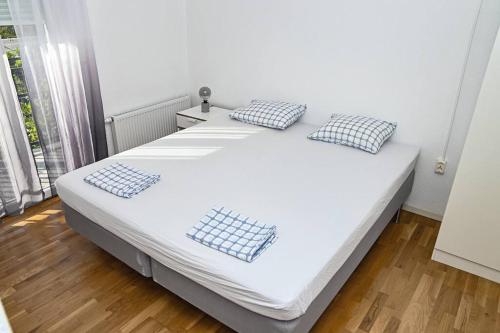 a white bed with black and white pillows on it at Villa Carpenter in Trebinje