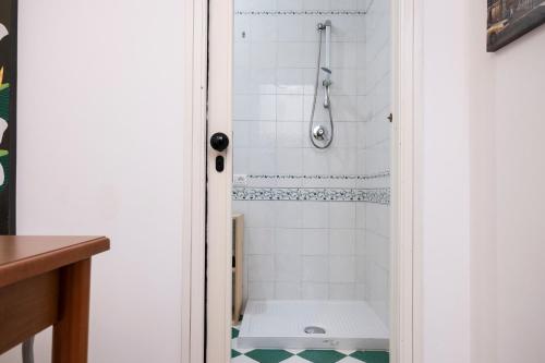 y baño con ducha y bañera de azulejos blancos. en Appartamento Cortese, en San Vito lo Capo