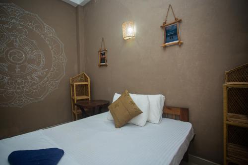 a bedroom with a bed with white sheets and pillows at koggala House By The Rock in Habaraduwa
