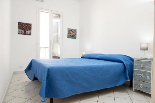 Un dormitorio blanco con una cama azul y un tocador en Appartamento Cortese, en San Vito lo Capo