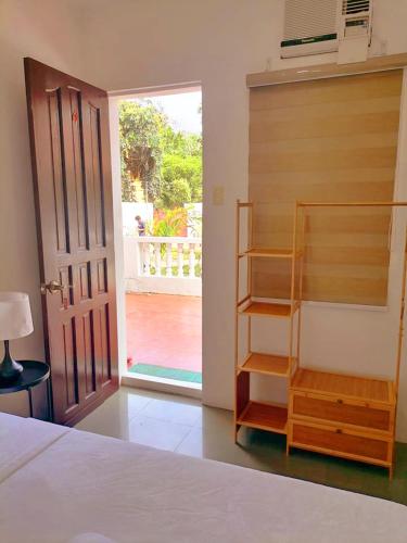 a bedroom with a bed and a book shelf next to a door at Victoria's Inn by Martha Vacation Homes in Boracay