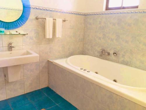 a bathroom with a tub and a sink at Victoria's Inn by Martha Vacation Homes in Boracay