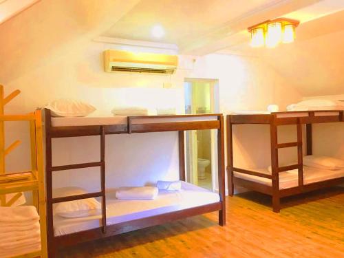 a room with three bunk beds in a room at Victoria's Inn by Martha Vacation Homes in Boracay