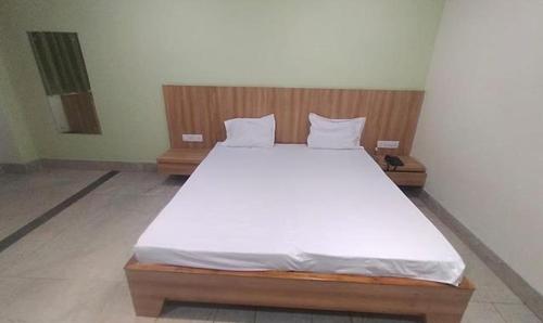 sypialnia z dużym łóżkiem z białą pościelą w obiekcie FabHotel Park Mahindra w mieście Raipur
