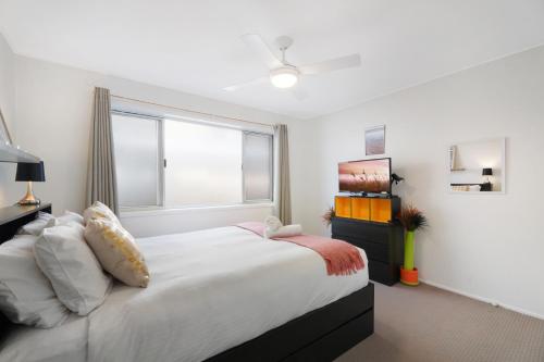 um quarto com uma cama grande e uma janela em Two-bedroom Beachside Apartment with Parking em Gold Coast