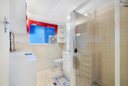 a bathroom with a shower and a toilet at Two-bedroom Beachside Apartment with Parking in Gold Coast