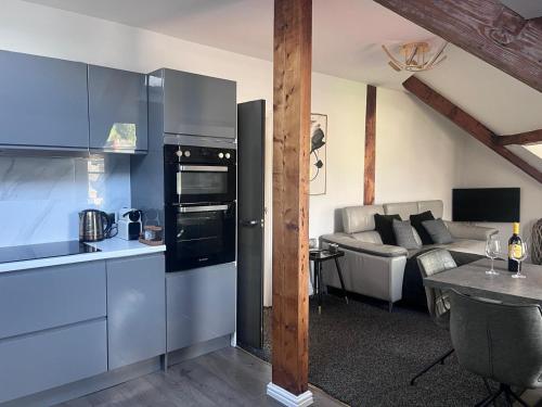 a kitchen with stainless steel appliances and a living room at The Penthouse in Windermere in Windermere