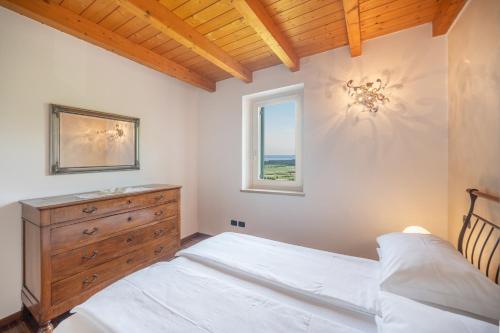 um quarto com uma cama com uma cómoda e uma janela em La Rubiana Apartment em Caprino Veronese