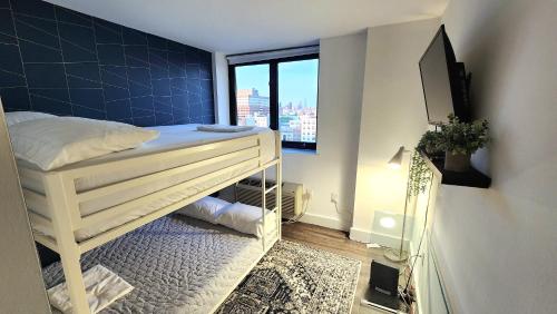 a small bedroom with a bunk bed and a tv at City Views Penthouse NYC in 5min in Hoboken
