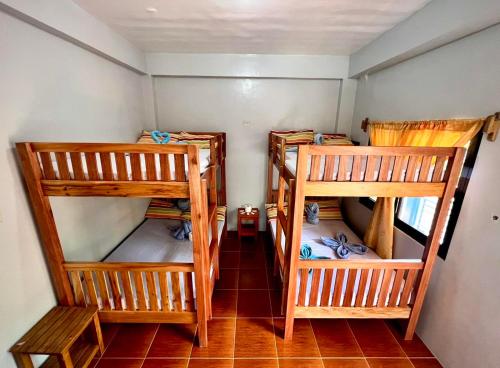 a room with three bunk beds in a room at Lotus Sun & Waves Beach Resort in Baler