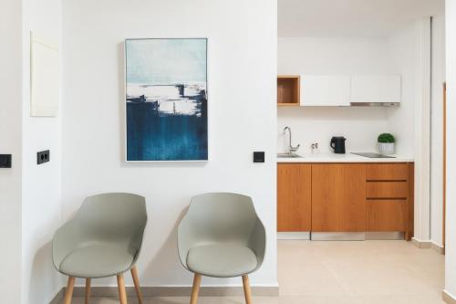 two chairs in a kitchen with a painting on the wall at Diamond Star Hotel in Falasarna