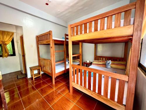 a room with two bunk beds in a house at Lotus Sun & Waves Beach Resort in Baler