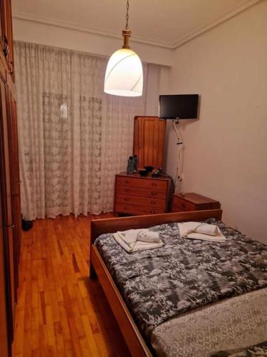 a bedroom with a bed and a dresser and a television at Efchi city center apartment in Katerini