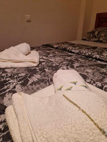 two white towels are sitting on a bed at Efchi city center apartment in Katerini