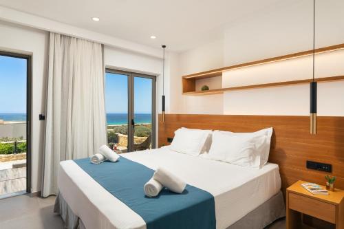 a bedroom with a bed with a view of the ocean at Diamond Star Hotel in Falasarna