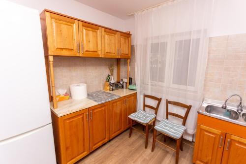 a small kitchen with wooden cabinets and a sink at CASA RUMELIA in Păltineni