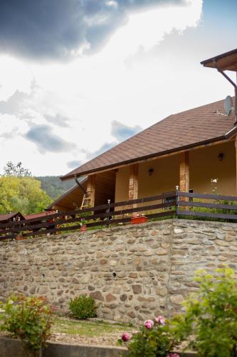 a stone wall in front of a house at CASA RUMELIA in Păltineni