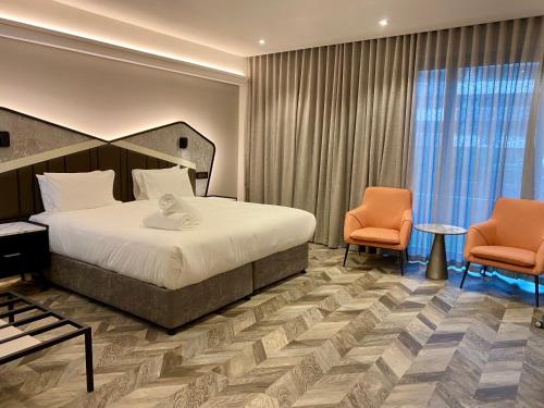 um quarto de hotel com uma cama e duas cadeiras em Coastlands Skye Hotel, Ridgeside, Umhlanga em Durban