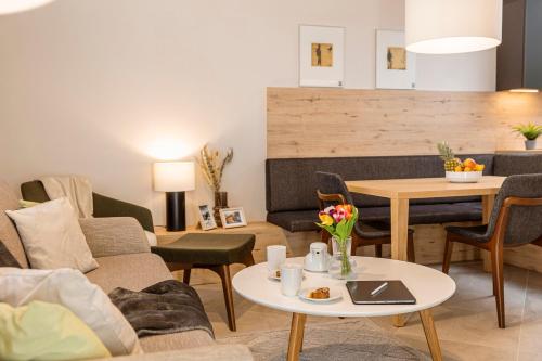 ein Wohnzimmer mit einer Couch und einem Tisch in der Unterkunft Bergresort Gerlitzen by ALPS RESORTS in Treffen