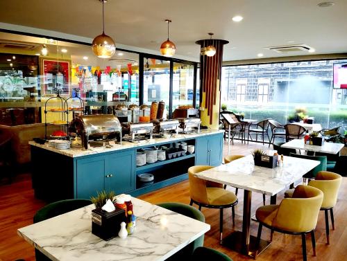 a restaurant with two tables and chairs and a kitchen at Siri Oriental Bangkok Hotel in Bangkok