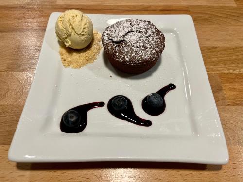 a plate with a chocolate cupcake and a ice cream at Hotel Restaurant Le Clos in Besse-et-Saint-Anastaise