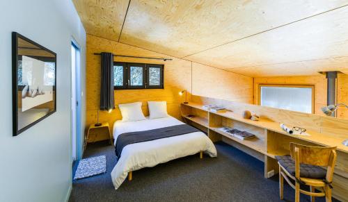 1 dormitorio con 1 cama y escritorio en una habitación en Kabane 49, en Niort