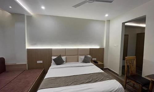 a bedroom with two beds and a ceiling fan at FabHotel Prakash in Ujjain