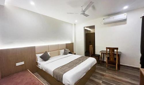 a bedroom with a bed and a desk with a fan at FabHotel Prakash in Ujjain