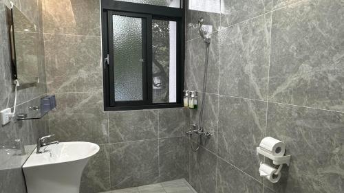 een badkamer met een wastafel en een douche met een raam bij 包棟陌上花加賴詢問優惠moshang446電麻烤肉switch in Hualien