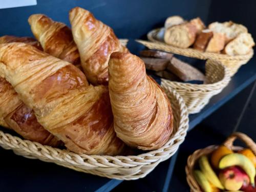 a bunch of croissants and other pastries in baskets at Hotel Restaurant Le Clos in Besse-et-Saint-Anastaise