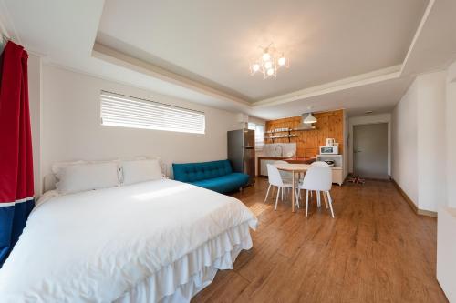 a bedroom with a bed and a table and chairs at Walking Sky Pension in Gapyeong
