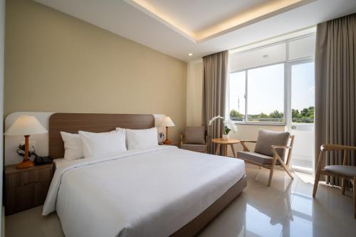 a bedroom with a large bed and a large window at The HUB Hotel - Airport in Ho Chi Minh City