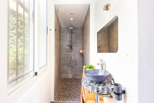 une salle de bain avec un lavabo et une douche dans l'établissement Les lucioles, à Beausoleil