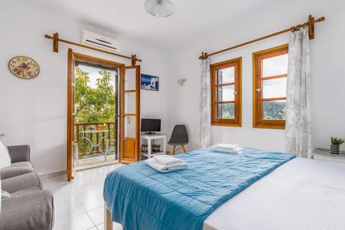 a bedroom with a bed and a chair and a window at Skopelos Property Apartment 1 in Panormos Skopelos