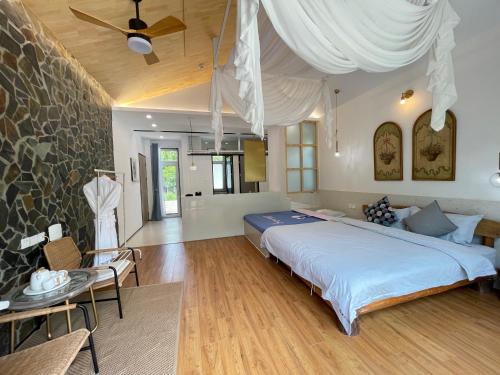 una camera con un grande letto e un muro di pietra di Starstay Wuling Mountain B&B a Xinglong