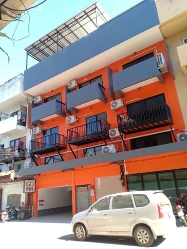 a white car parked in front of a building at GO INN Chiang Mai University - CMU โกอินน์ มหาวิทยาลัยเชียงใหม่ in Chiang Mai